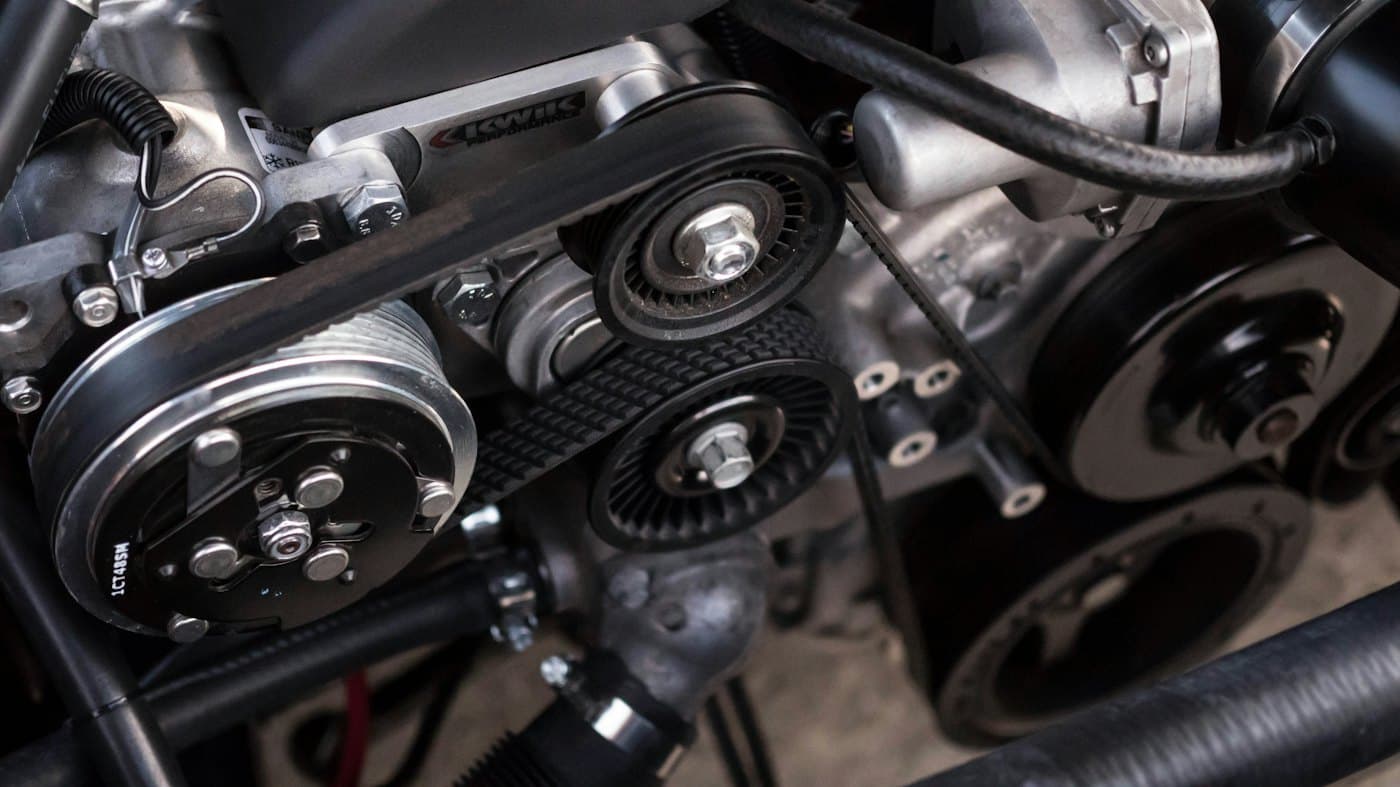Detalle de bandas y poleas de un motor en taller